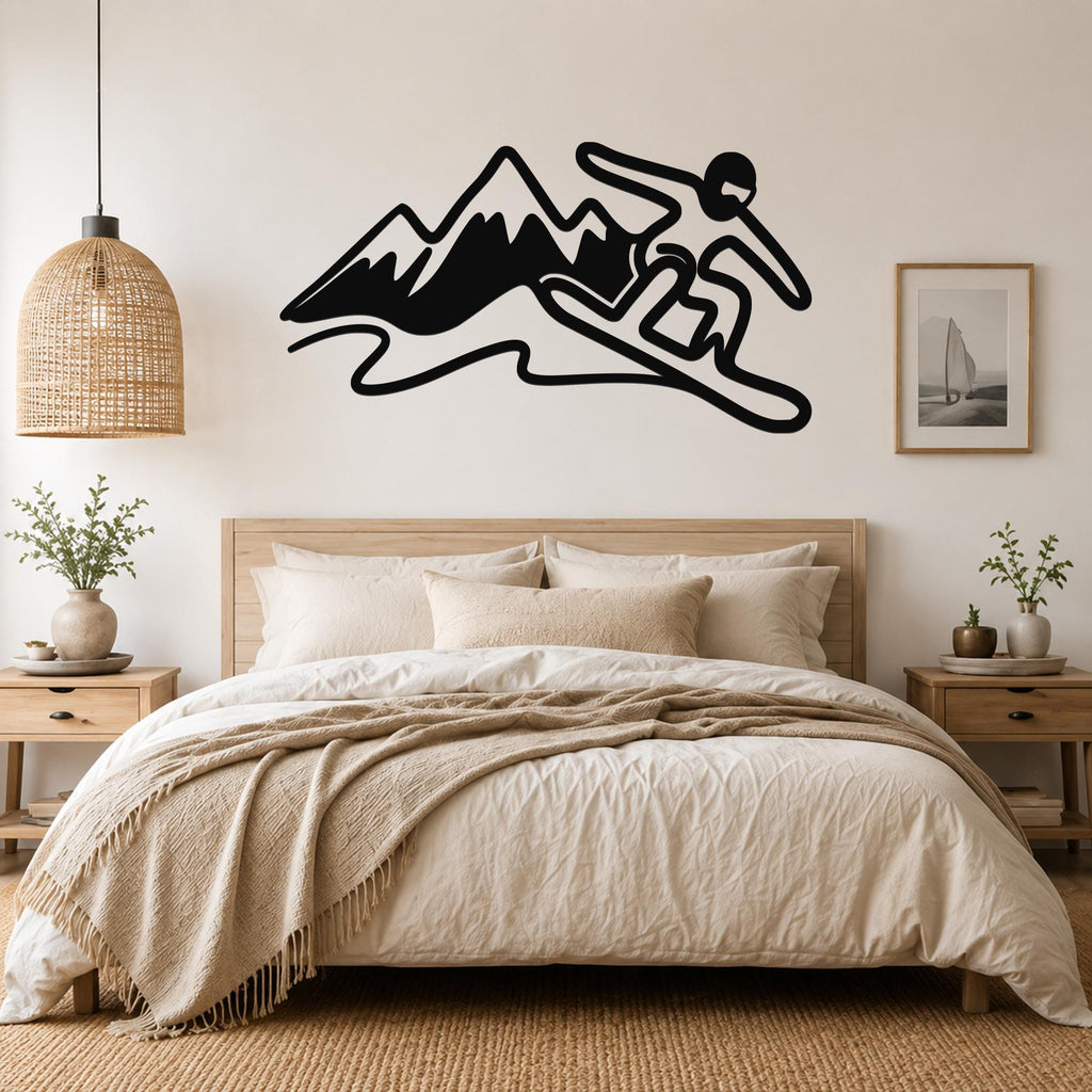 Black metal wall art silhouette of a snowboarder in motion above a bed, mounted on a light-colored bedroom wall.