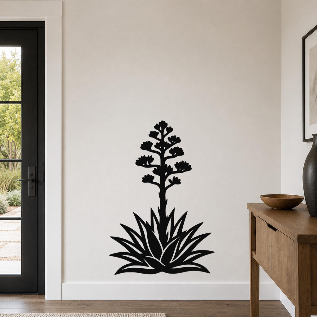 Black metal agave wall art with a blooming flower silhouette, mounted on a white wall in a living room.