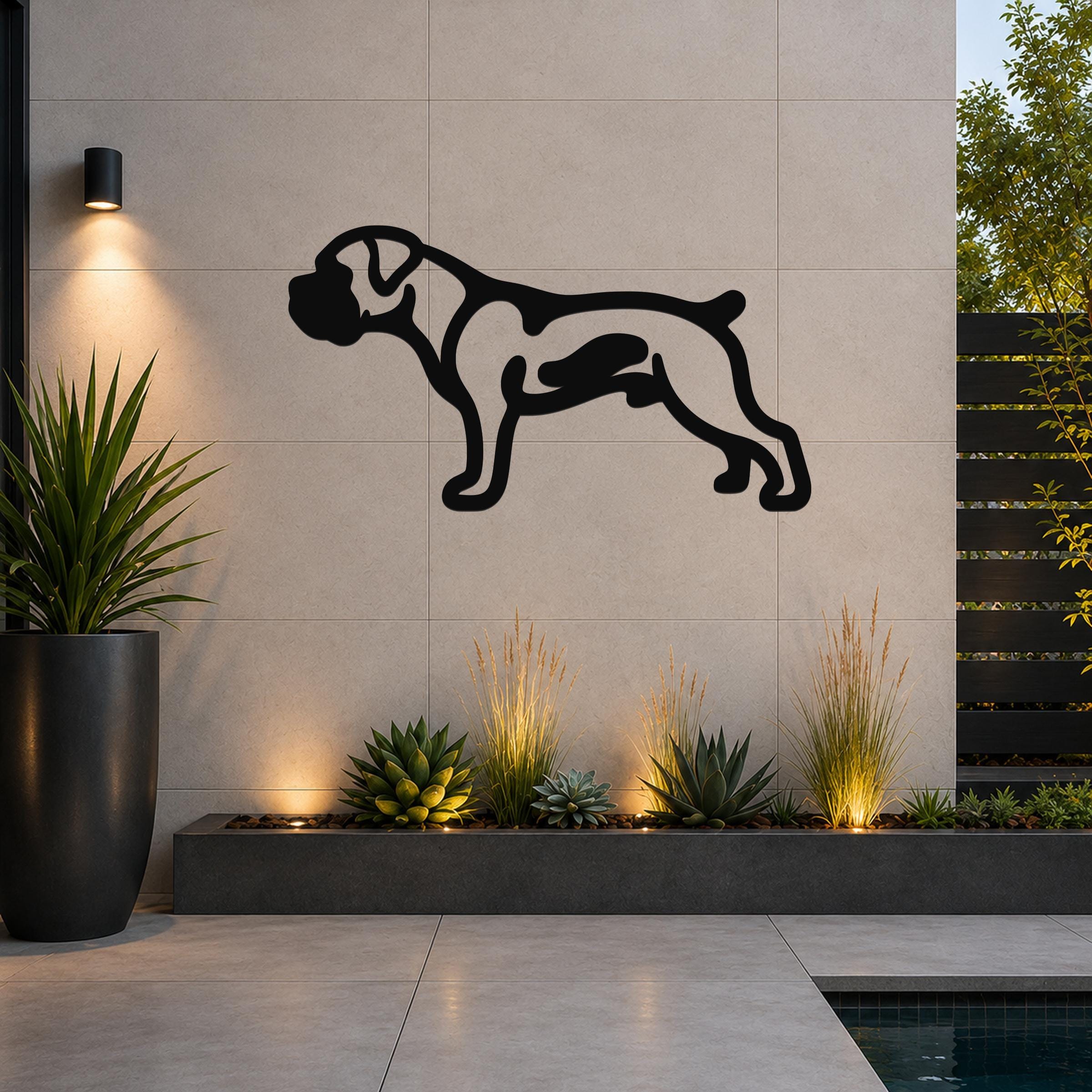 Black metal Boxer dog wall art silhouette with internal cutouts, mounted on a light gray tiled outdoor wall above a planter with succulents and uplighting.