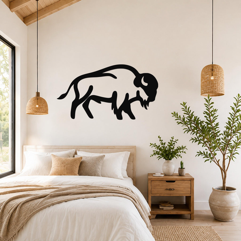 Black metal buffalo silhouette wall art mounted above a bed in a bedroom with wooden furniture and woven pendant lights.