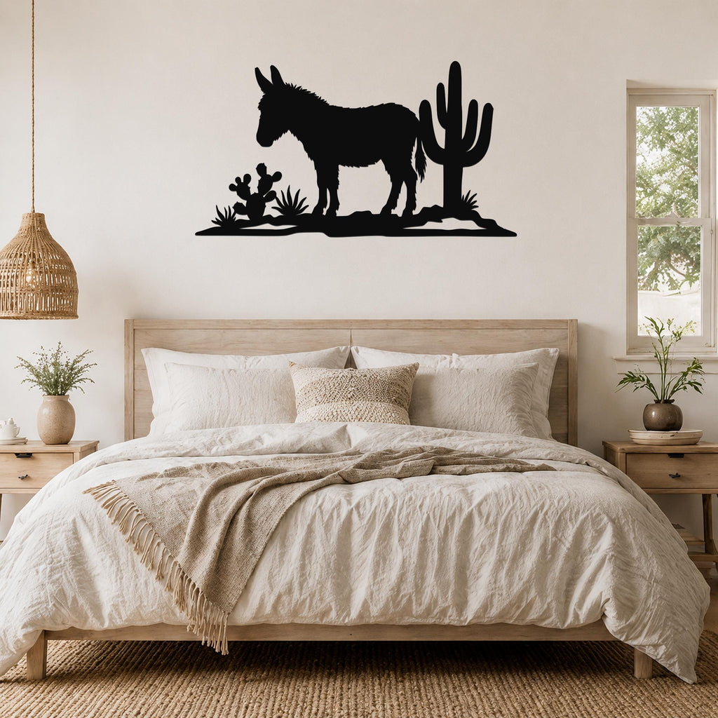 Black metal wall art silhouette of a burro and cacti, mounted above a bed in a bedroom.