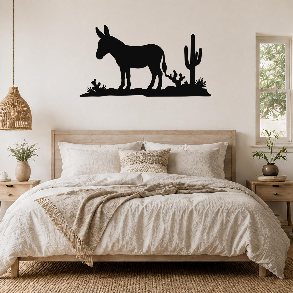Black metal wall art silhouette of a burro and cacti, mounted above a bed in a rustic bedroom.