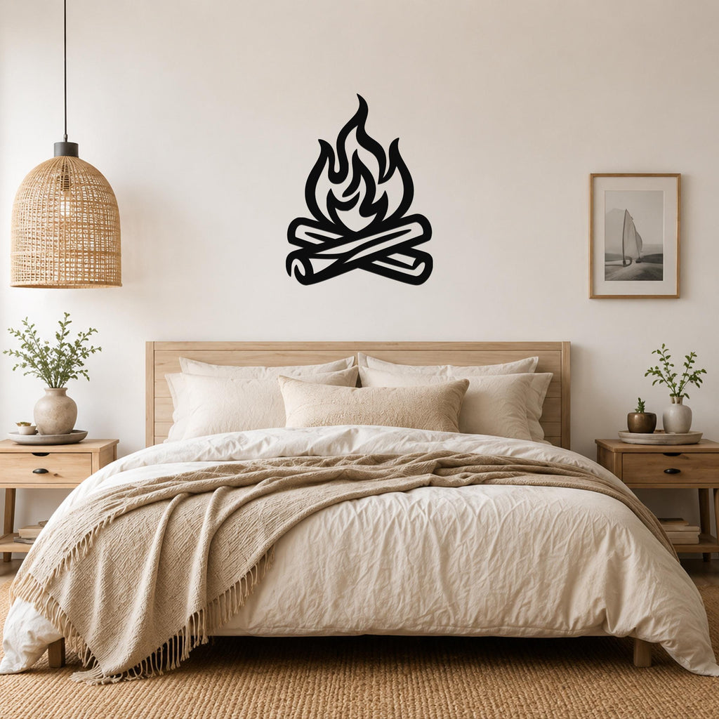 Black metal campfire wall art with flame and log silhouette, mounted above a bed in a neutral bedroom.