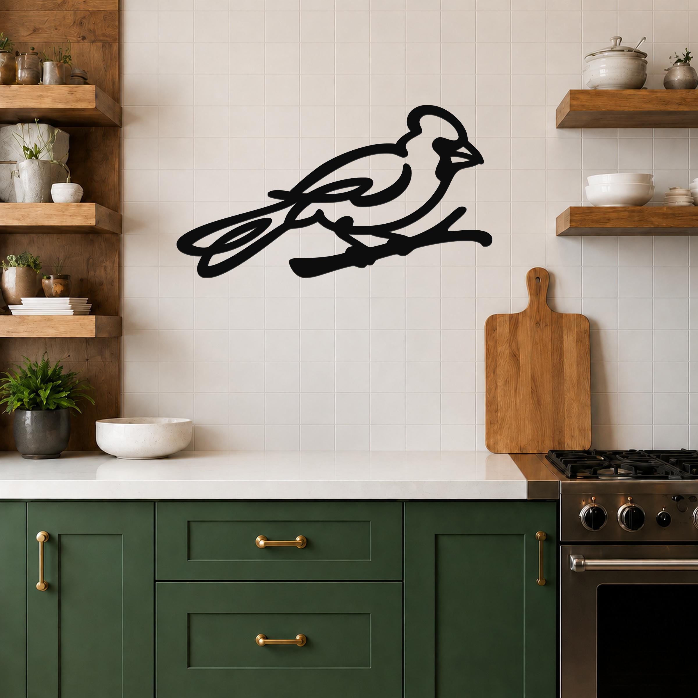 Black metal cardinal wall art in a minimalist silhouette style, mounted on a tiled kitchen wall above a counter.