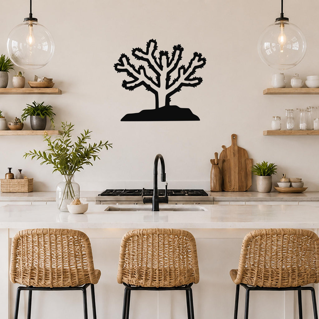 Black metal Cholla cactus wall art with branching silhouette, mounted on a kitchen wall above a counter.