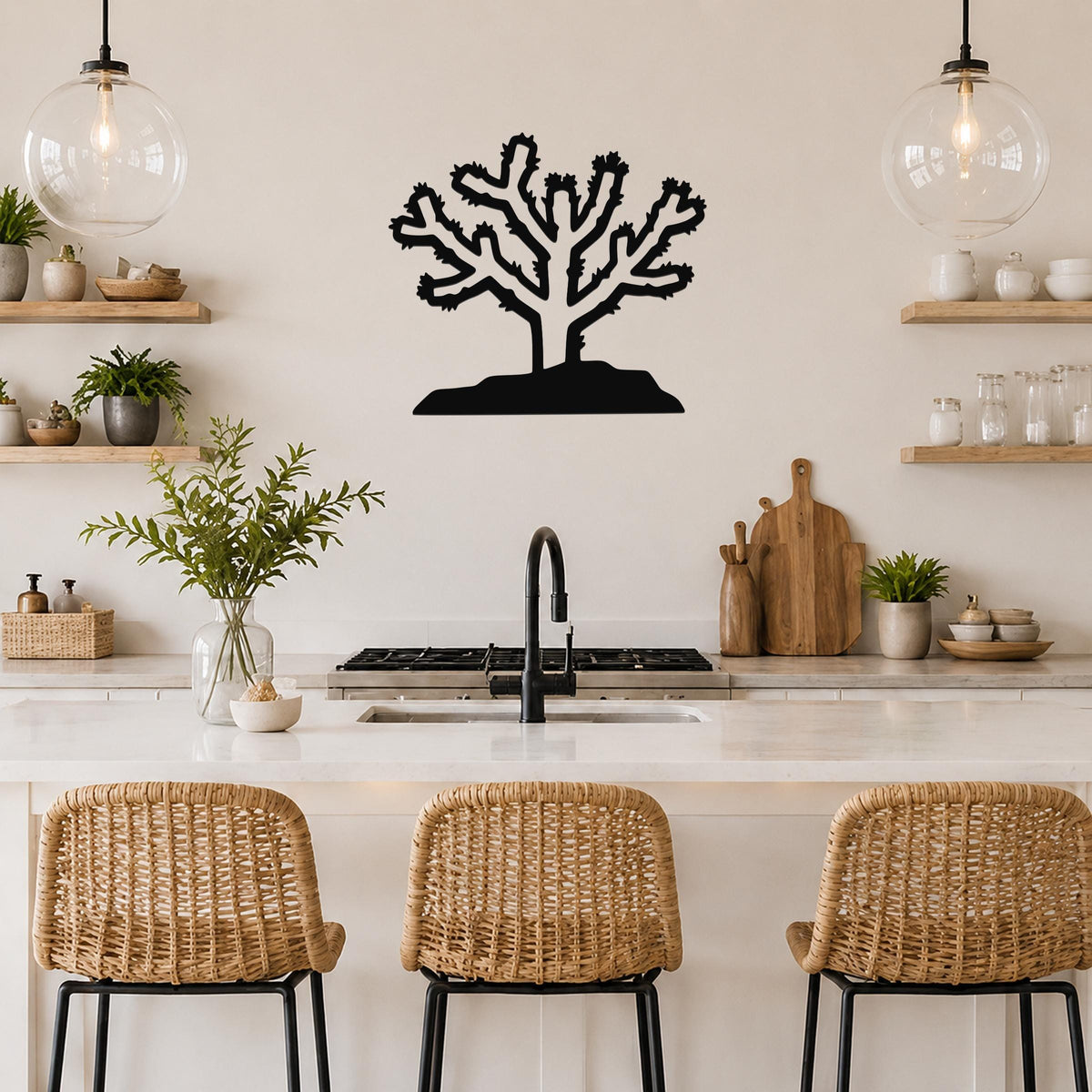Black metal Cholla cactus wall art with branching silhouette, mounted on a kitchen wall above a counter.
