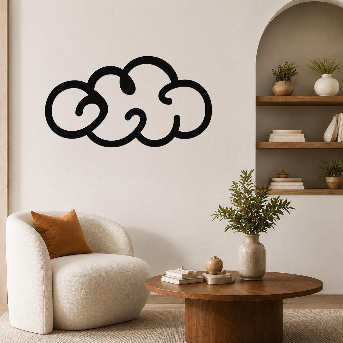 Black metal cloud wall art with a bold silhouette design, mounted on a living room wall above a round wooden coffee table.