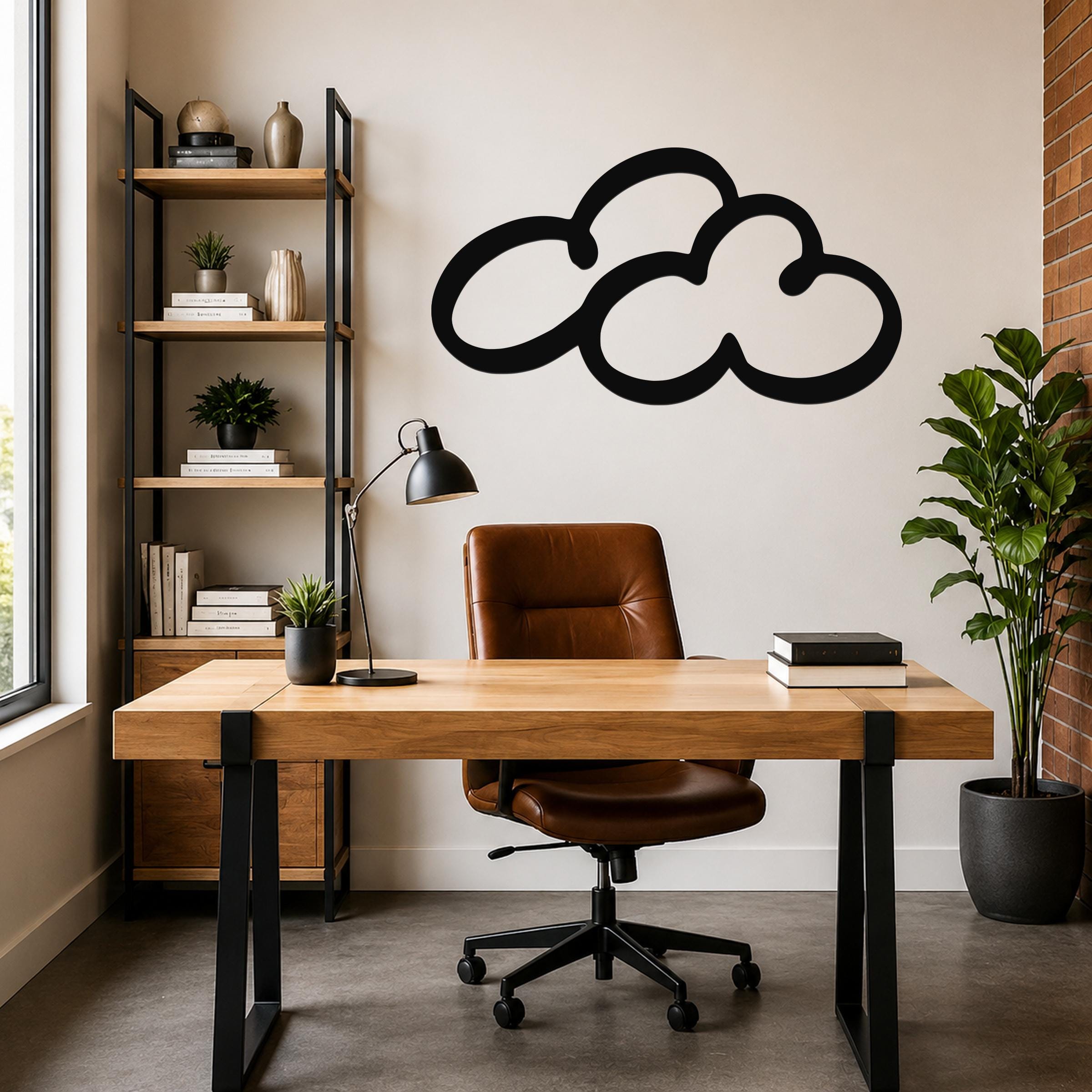 Black metal cloud wall art with a bold silhouette design, mounted on a light-colored wall above a wooden desk in a modern home office.