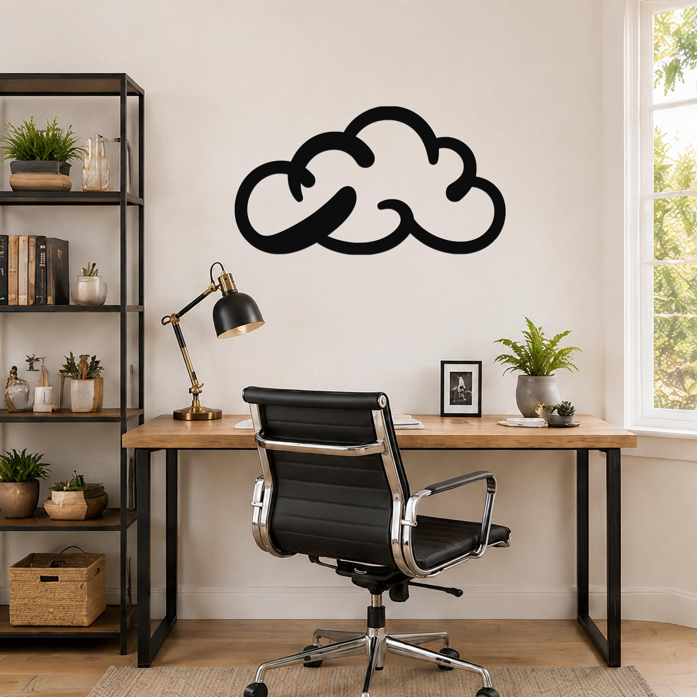 Black metal cloud wall art with a bold silhouette design, mounted on a wall above a wooden desk in a modern home office.