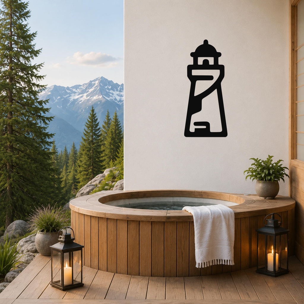 Black metal lighthouse wall art with internal cutout details, mounted on a white wall above a wooden hot tub on a deck with mountain views.