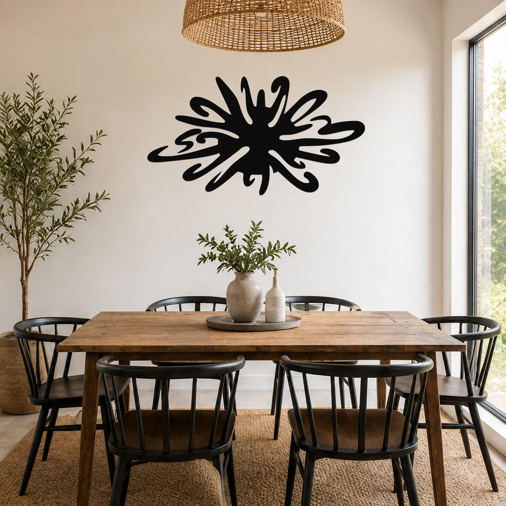 Black metal sea urchin wall art with organic spines and cutout details, mounted on a white wall above a wooden dining table in a bright dining room.