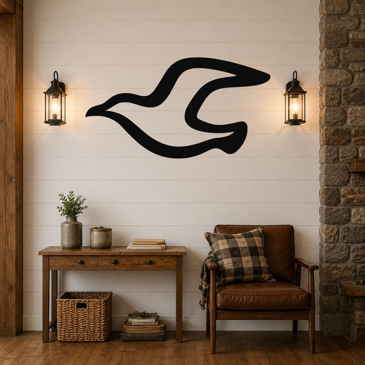 Black metal wall art in the silhouette of a seagull in flight, mounted on a shiplap wall above a wooden console table in a living room.