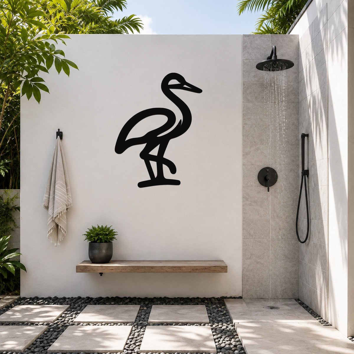Black metal crane wall art silhouette mounted on a white outdoor wall above a wooden bench in a modern shower area.
