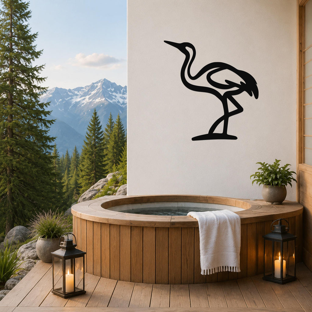 Black metal crane wall art silhouette mounted on a white wall above a wooden hot tub on a mountain-view deck.