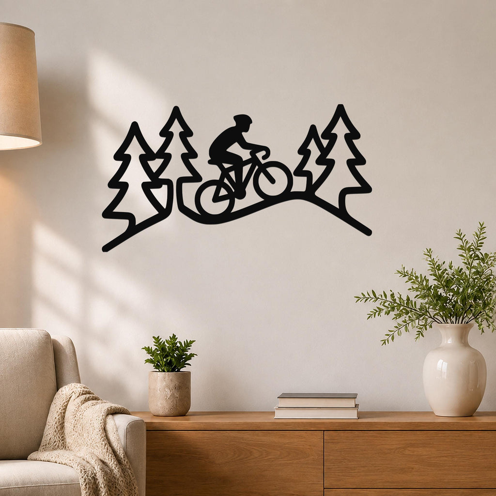 Black metal wall art featuring a cyclist silhouette riding through a forest of pine trees, mounted on a living room wall above a wooden console table.