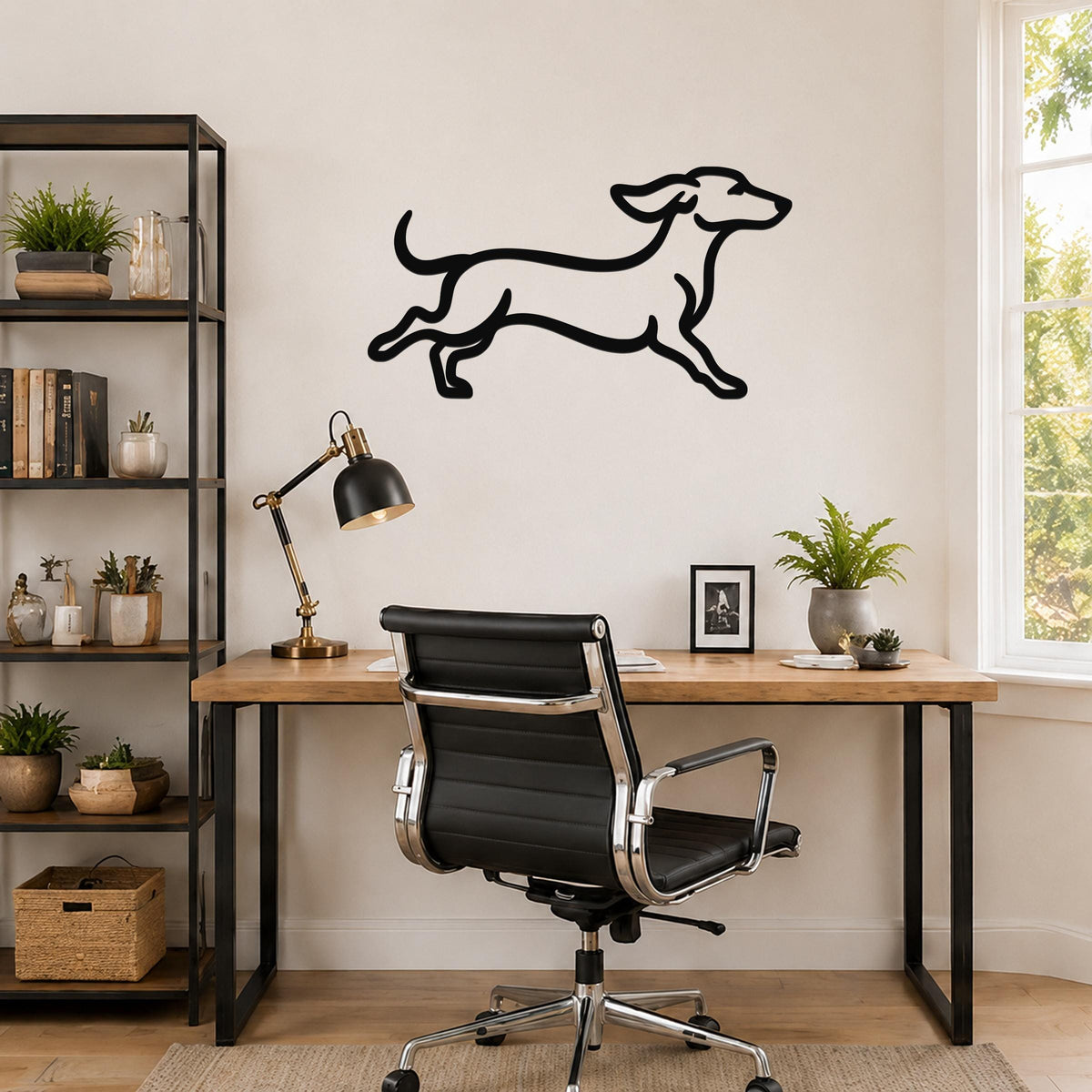 Black metal dachshund wall art with a running silhouette, mounted on a wall above a wooden desk in a home office.