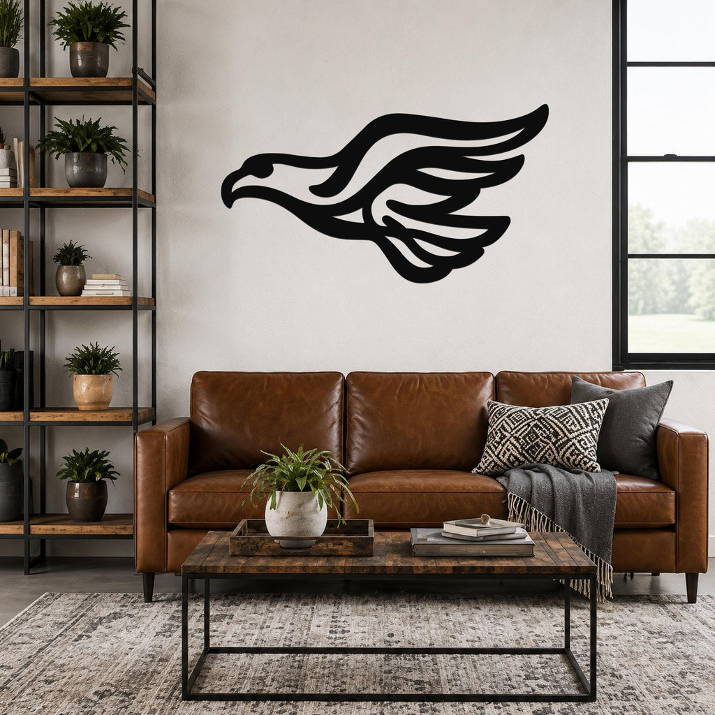 Black metal eagle wall art with flowing wing cutouts, mounted above a brown leather sofa in a living room.