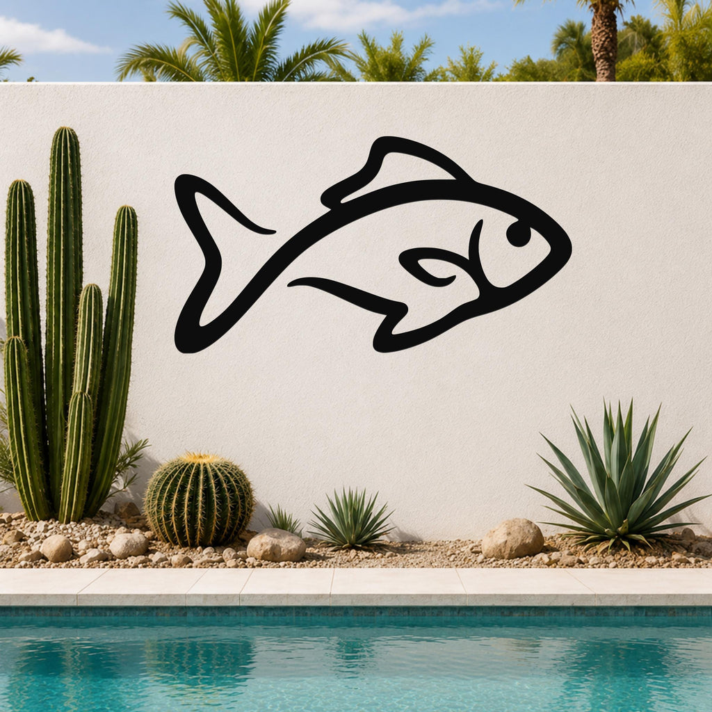 Black metal fish silhouette wall art with internal cutout details, mounted on a white outdoor wall beside a pool and cacti.