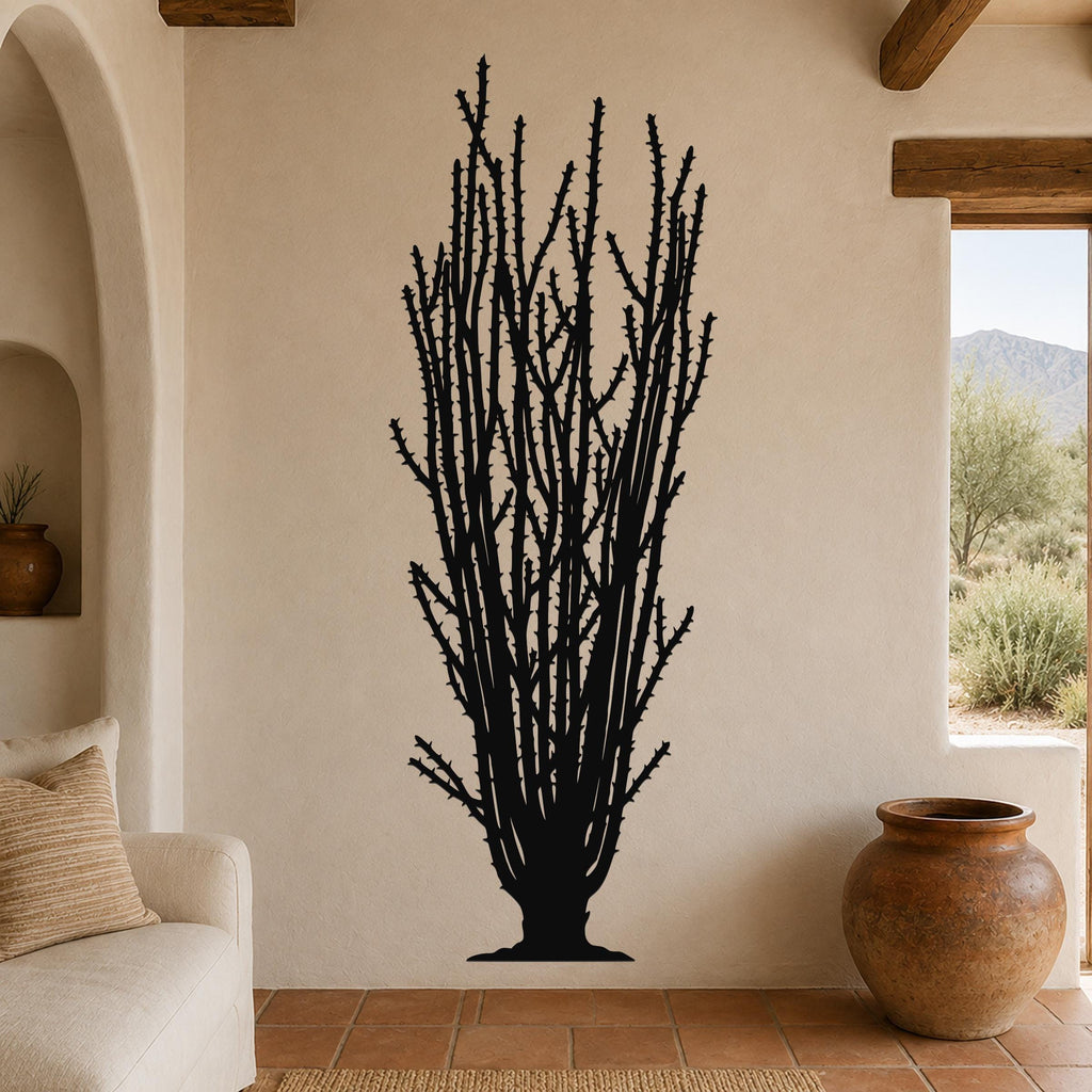 Black metal wall art silhouette of a tall ocotillo cactus with spiny branches, mounted on a beige living room wall above a sofa.
