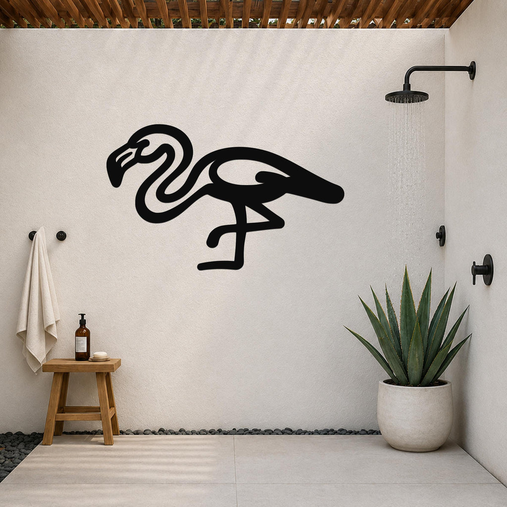 Black metal flamingo wall art with a minimalist silhouette design, mounted on a white outdoor shower wall above a small wooden stool and a potted succulent.