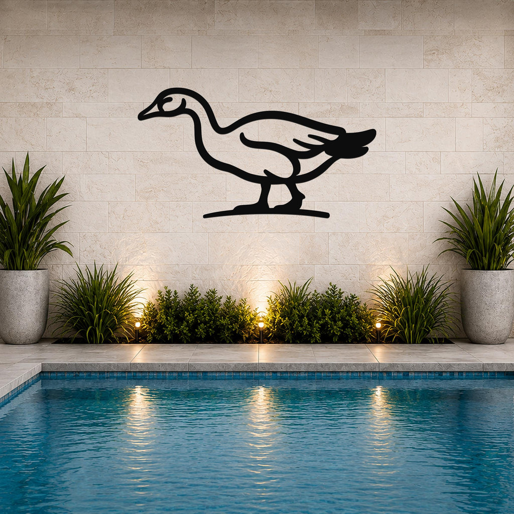 Black metal goose wall art silhouette mounted on a tiled wall above a pool, with potted plants and ground lights below.