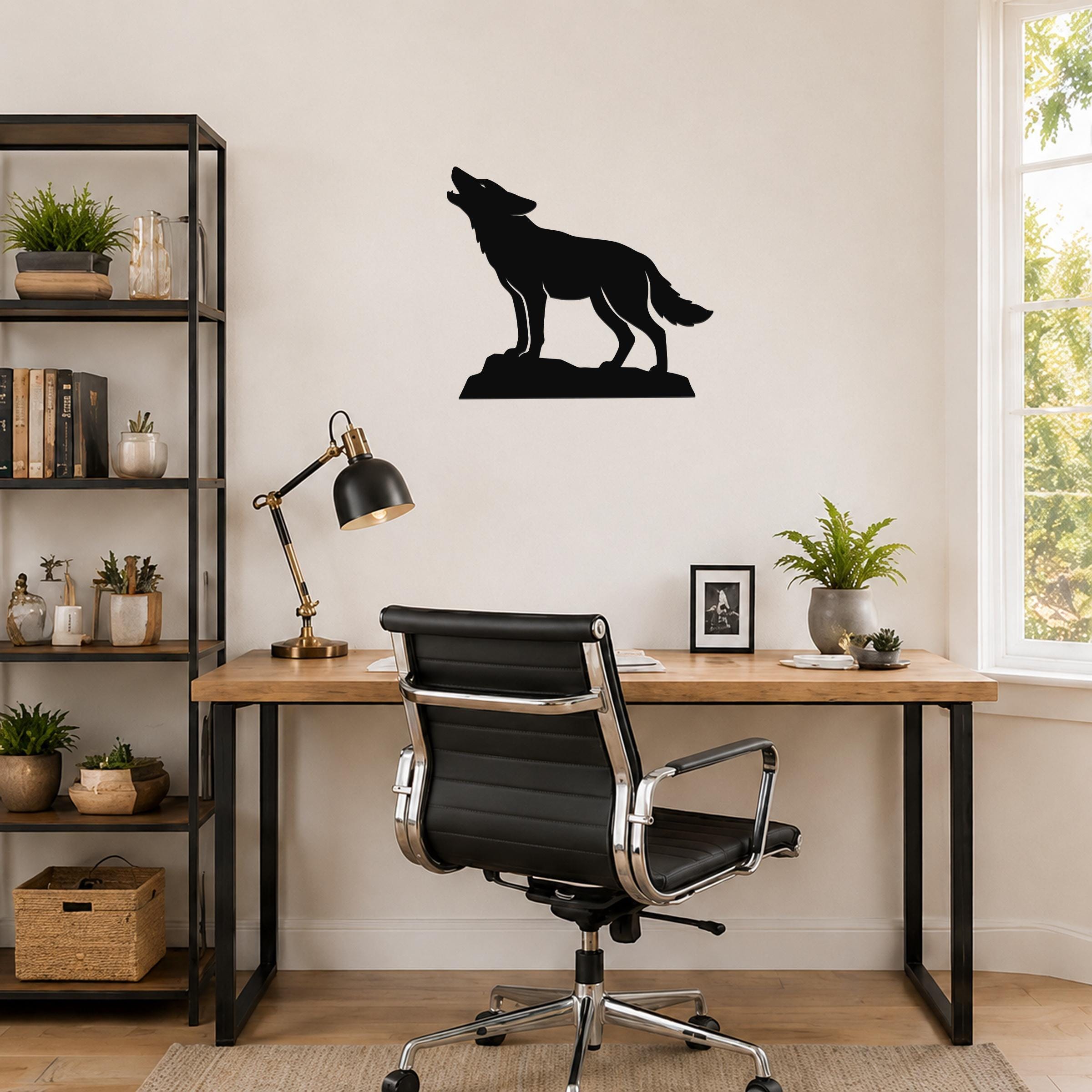 Black metal coyote wall art in a howling silhouette, mounted on a wall above a wooden desk in a home office.