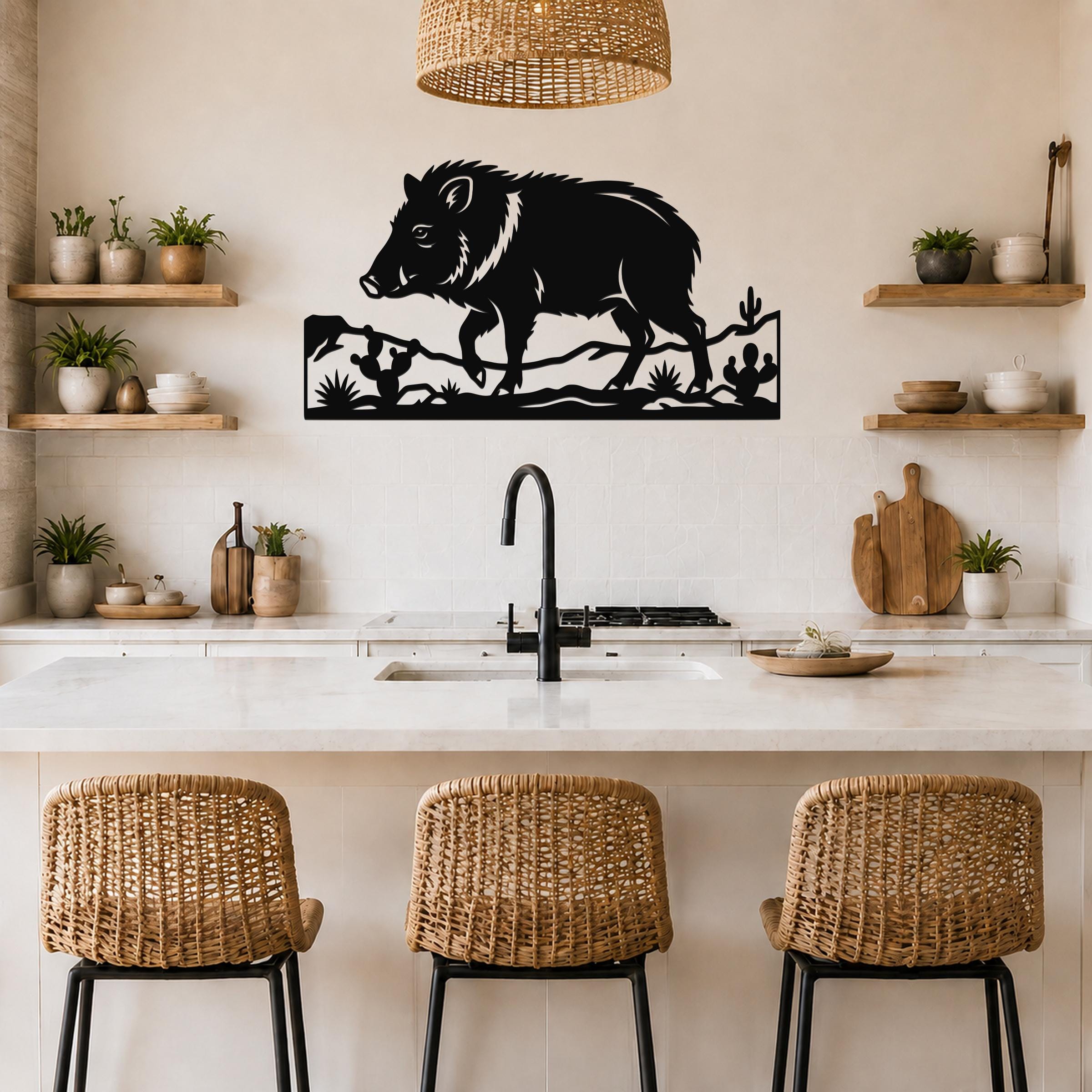 Black metal javelina wall art with cactus and terrain cutouts, mounted above a kitchen counter in a rustic kitchen.