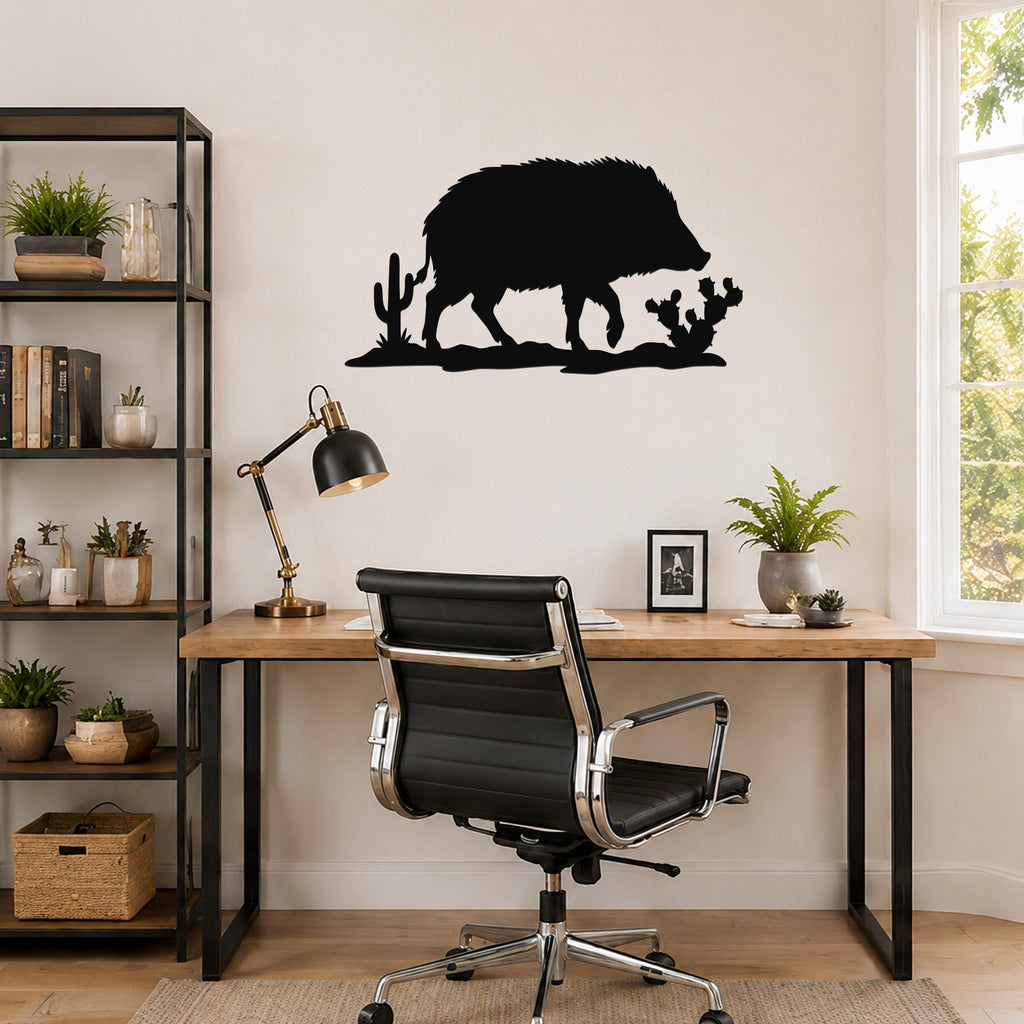 Black metal javelina wall art with cactus cutouts, mounted above a wooden desk in a home office.