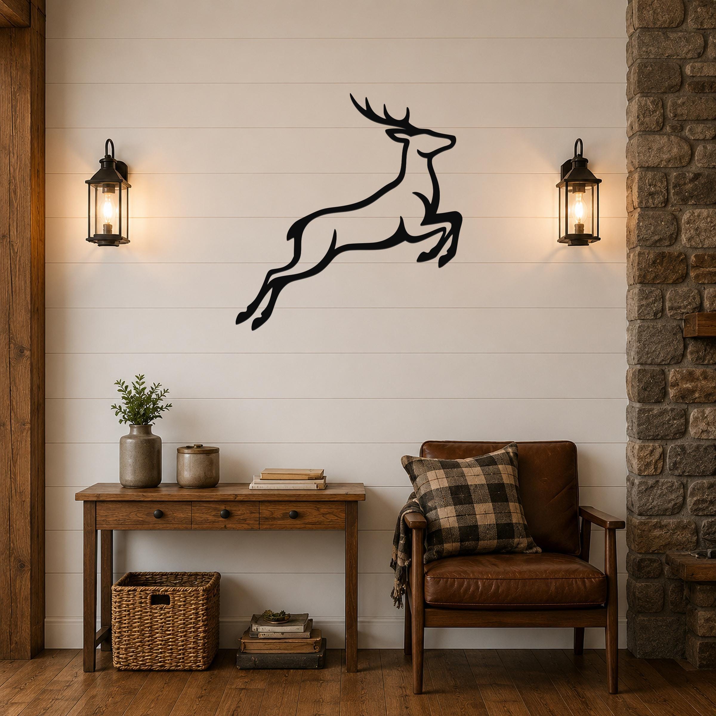 Black metal jumping deer wall art silhouette with motion lines, mounted on a shiplap wall above a wooden console table in a living room.
