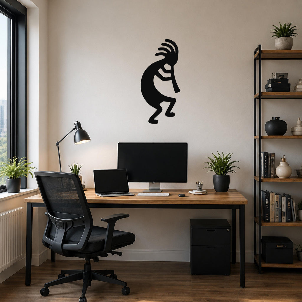 Black metal Kokopelli wall art silhouette with feathered headdress and flute, mounted on a beige wall above a wooden desk in a home office.