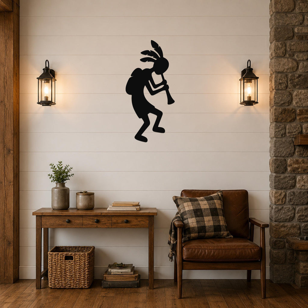 Black metal Kokopelli wall art silhouette playing a flute, mounted on a shiplap wall above a wooden console table in a living room.
