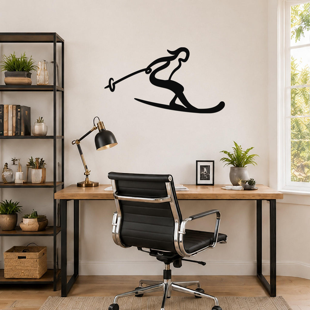 Black metal wall art of a skier silhouette with ski poles, mounted on a wall above a wooden desk in a home office.