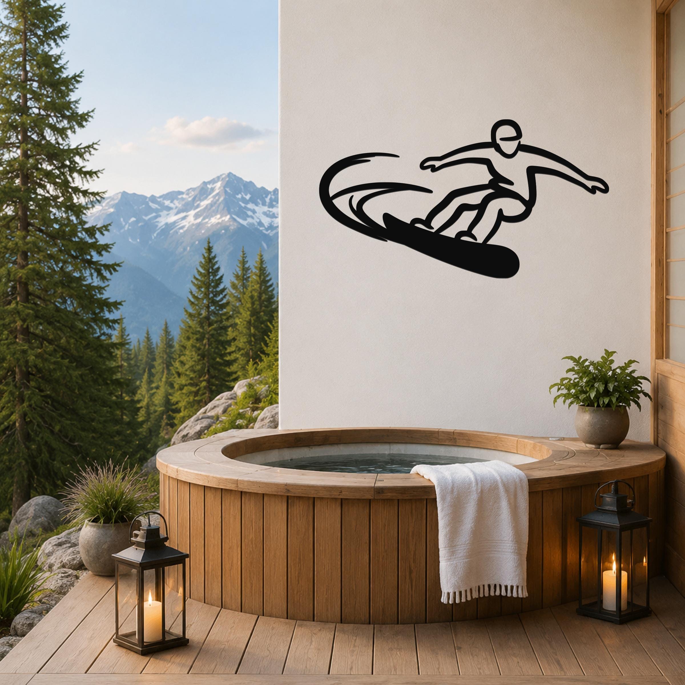Black metal wall art silhouette of a snowboarder in motion, mounted on a white wall above a wooden hot tub on a mountain-view deck.