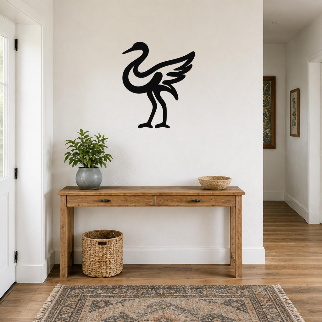 Black metal crane wall art in silhouette style, mounted on a white wall above a wooden console table in a hallway.
