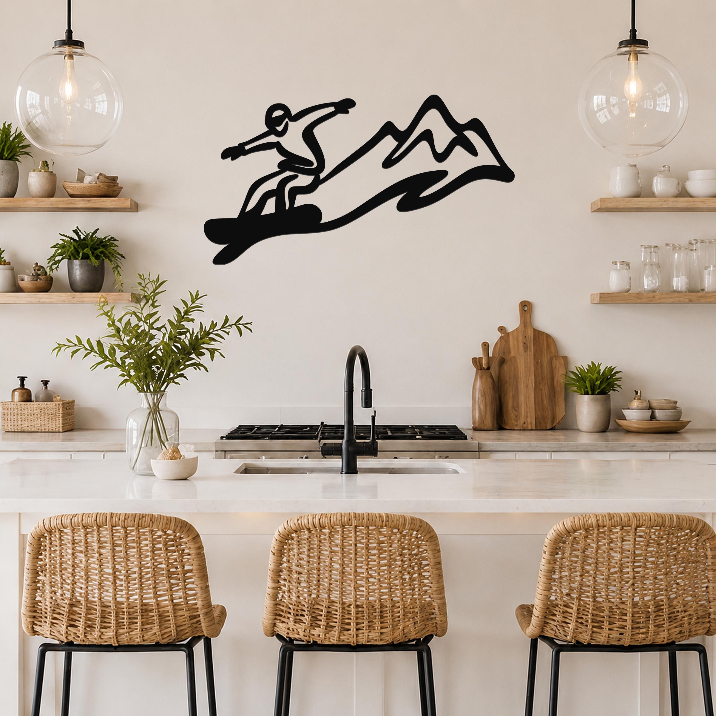 Black metal snowboarder wall art with mountain silhouette, mounted above a kitchen counter.