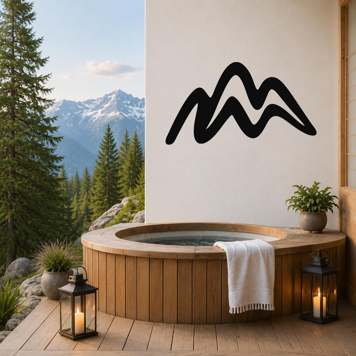 Black metal mountain silhouette wall art mounted on a white wall above a wooden hot tub on a deck with a mountain view.