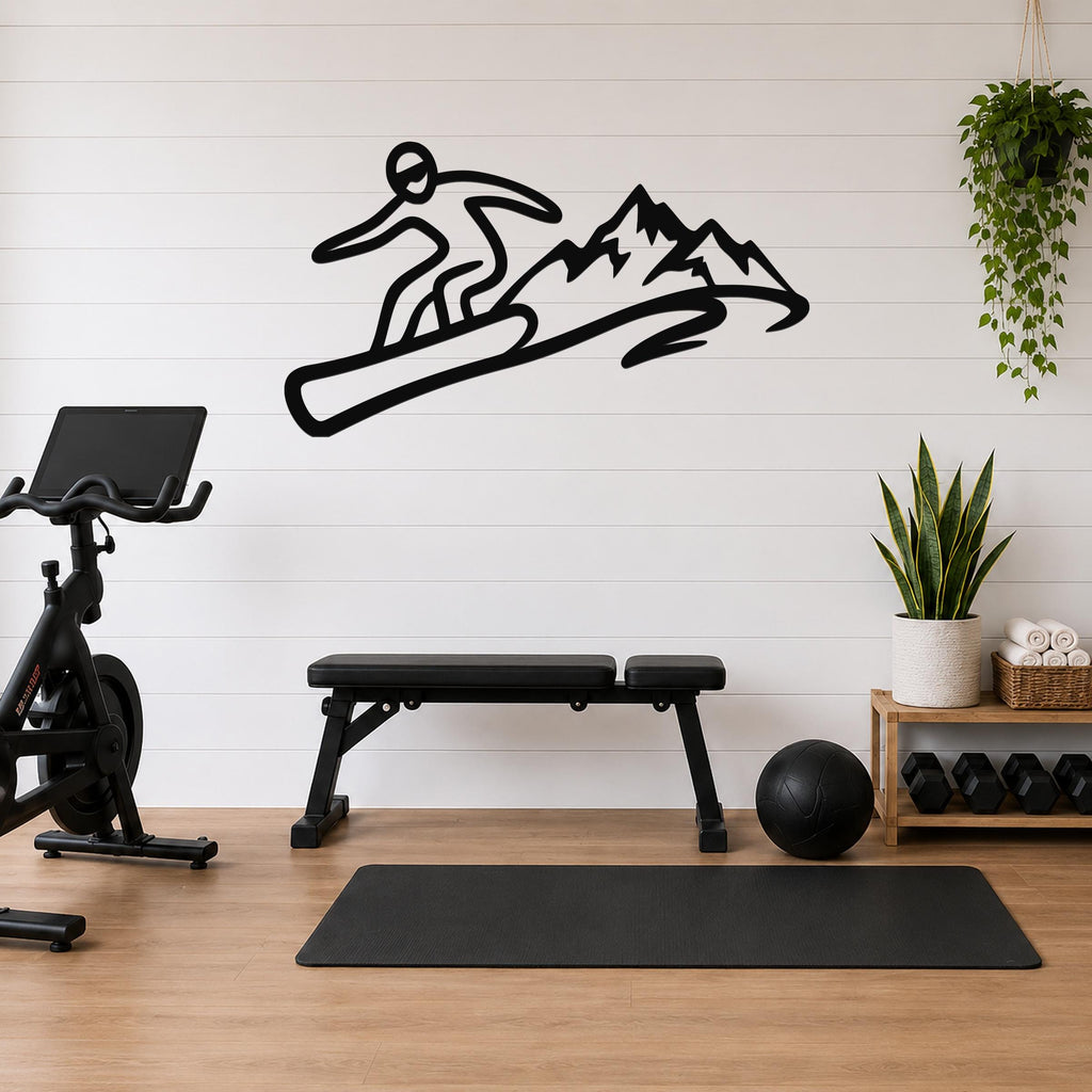 Black metal wall art featuring a snowboarder silhouette in dynamic motion above mountain peaks, mounted on a white shiplap wall above a workout bench in a home gym.