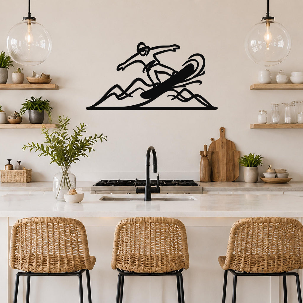 Black metal wall art silhouette of a snowboarder in motion, mounted above a kitchen counter with wicker bar stools.