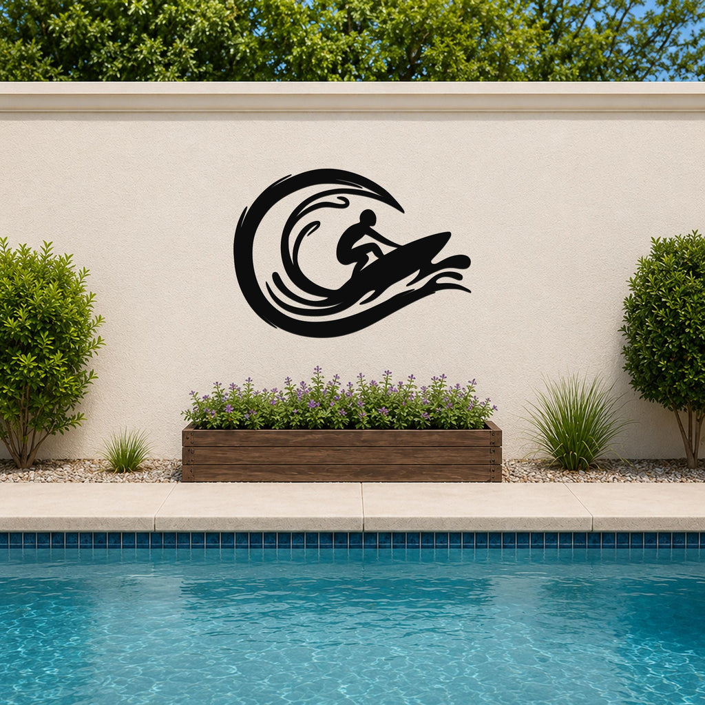Black metal wall art featuring a surfer silhouette riding a wave, mounted on an outdoor wall above a planter and pool.