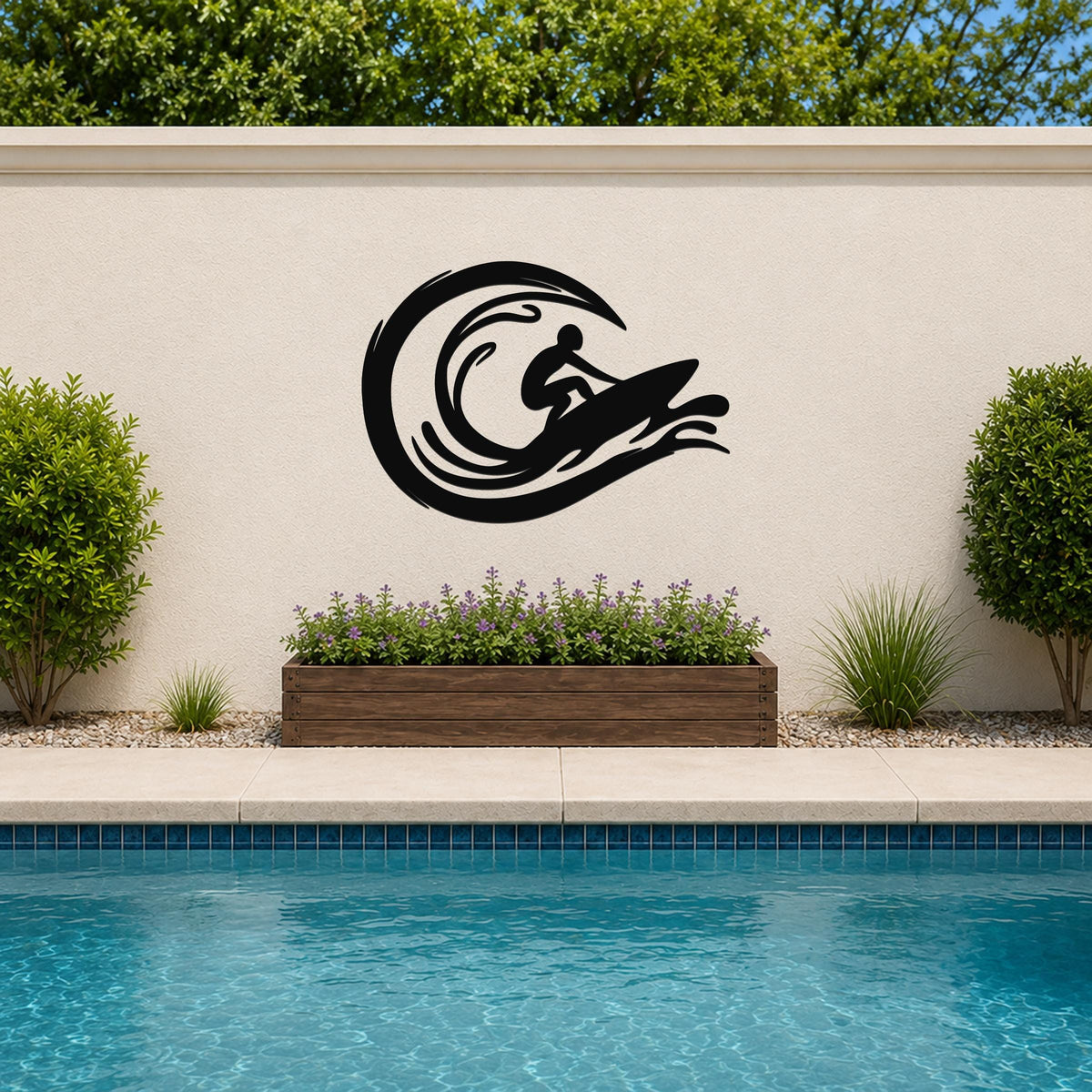 Black metal wall art featuring a surfer silhouette riding a wave, mounted on an outdoor wall above a planter and pool.
