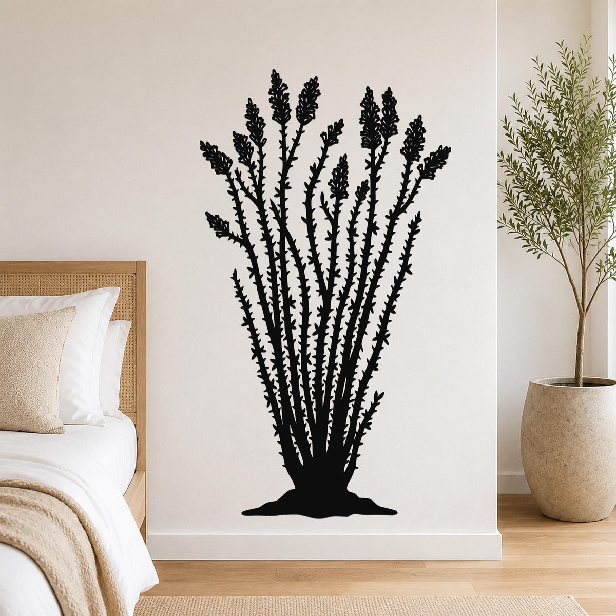 Black metal ocotillo wall art with detailed branch and flower cutouts, mounted on a bedroom wall above a bed.