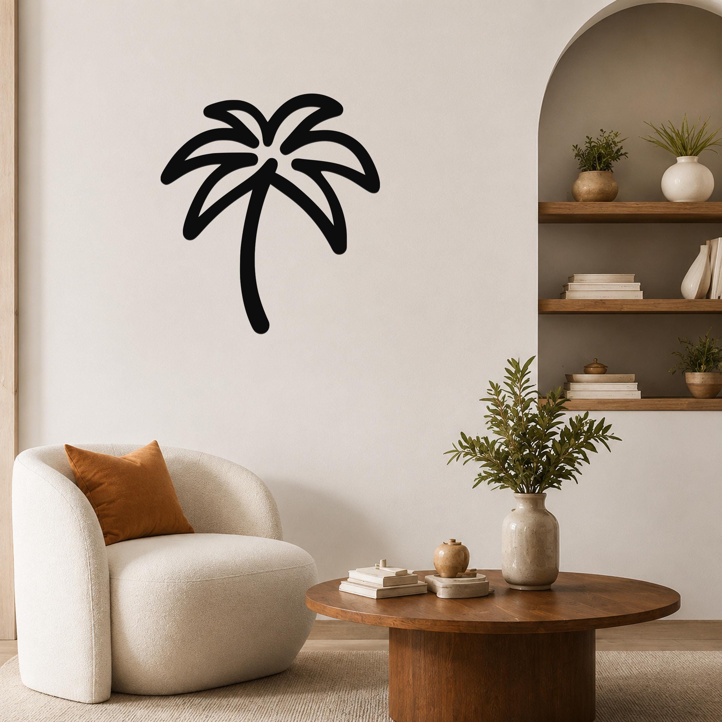 Black metal palm tree wall art with a silhouette design, mounted on a living room wall above a white armchair.