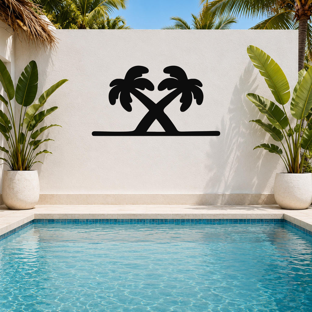 Black metal palm tree wall art with two crossed silhouettes, mounted on a white outdoor wall above a pool.