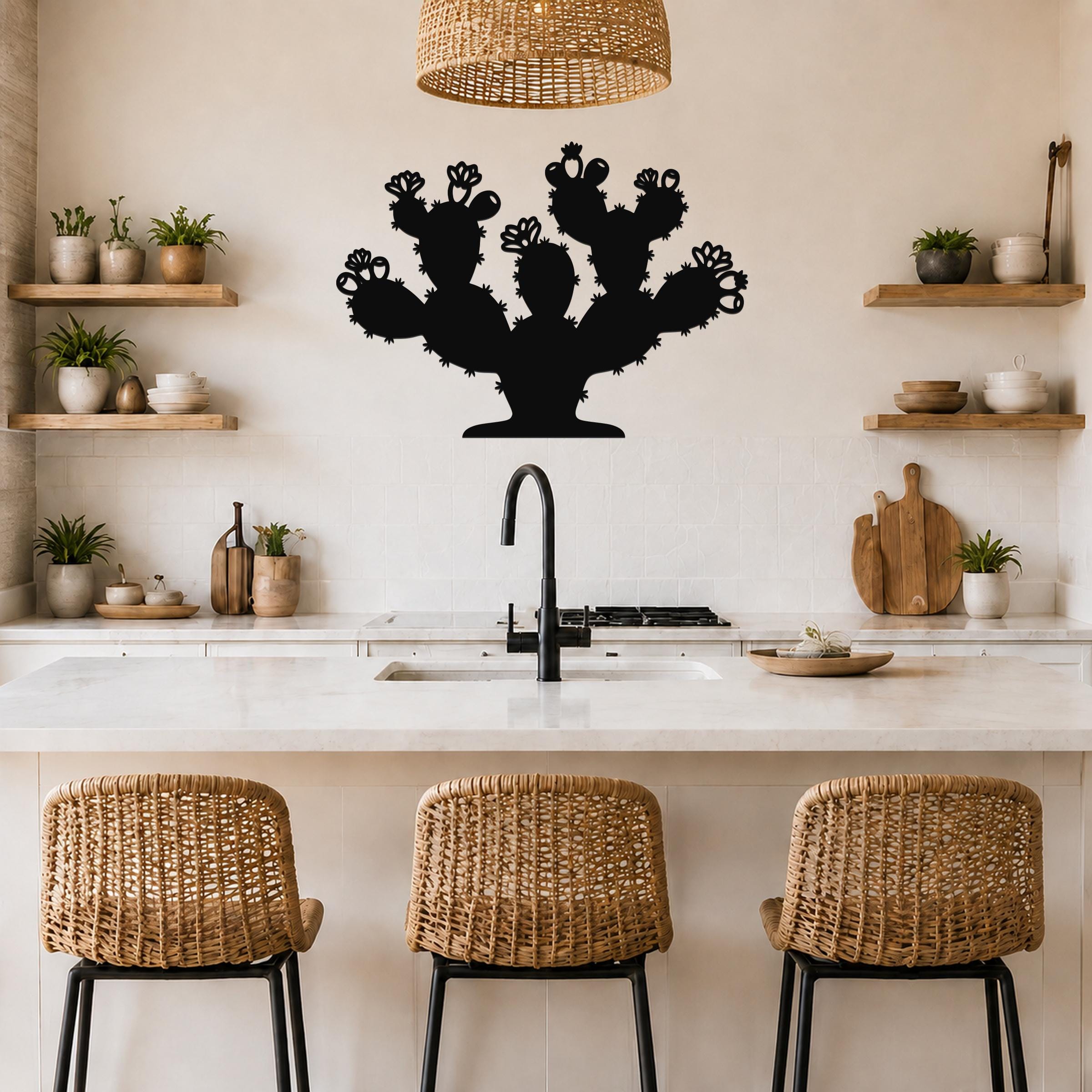 Black metal prickly pear cactus wall art with detailed flower and spine cutouts, mounted on a kitchen wall above a counter.
