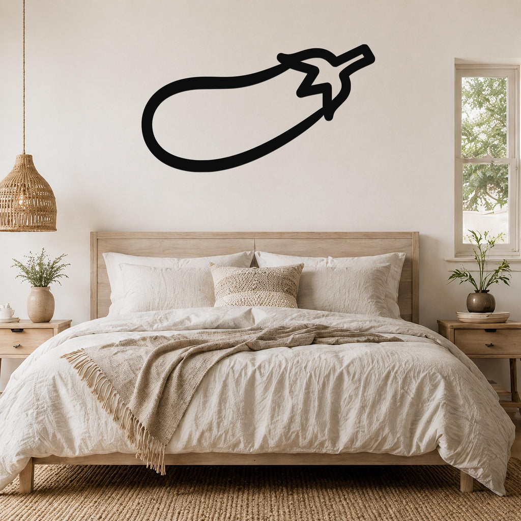Black metal eggplant wall art in a bold silhouette style, mounted above a wooden bed in a neutral bedroom.