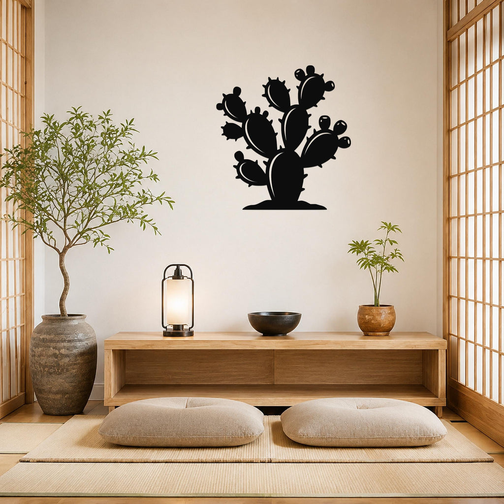 Black metal cactus wall art with multiple paddle-shaped segments and spines, mounted on a light-colored wall above a wooden console in a minimalist room.
