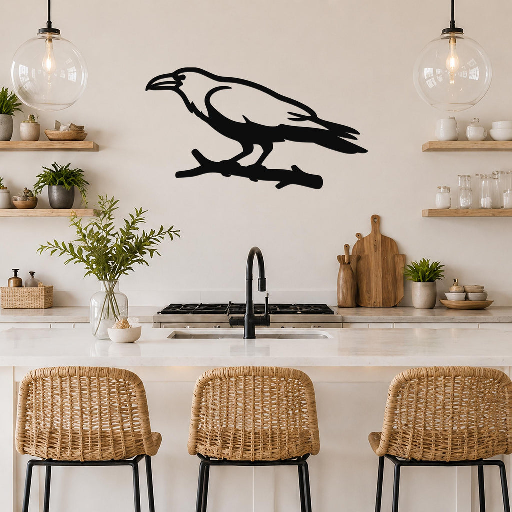 Black metal raven wall art silhouette perched on a branch, mounted above a kitchen counter with open shelving and pendant lights.