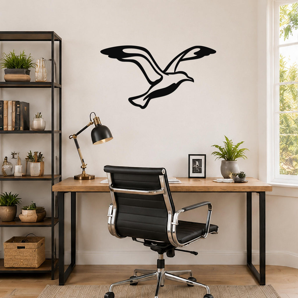 Black metal seagull wall art with motion-line cutouts, mounted above a wooden desk in a home office.