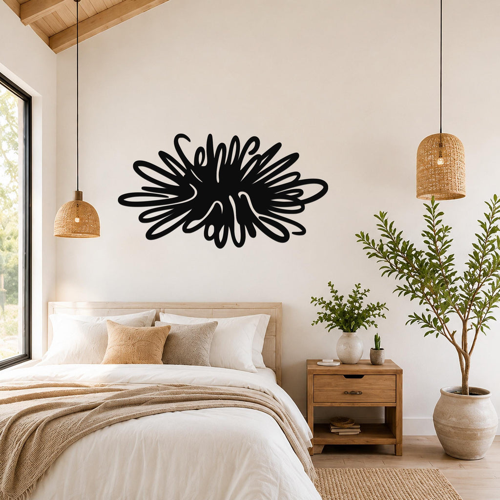 Black metal sea urchin wall art with spiky, radiating cutouts, mounted above a bed in a bright bedroom.
