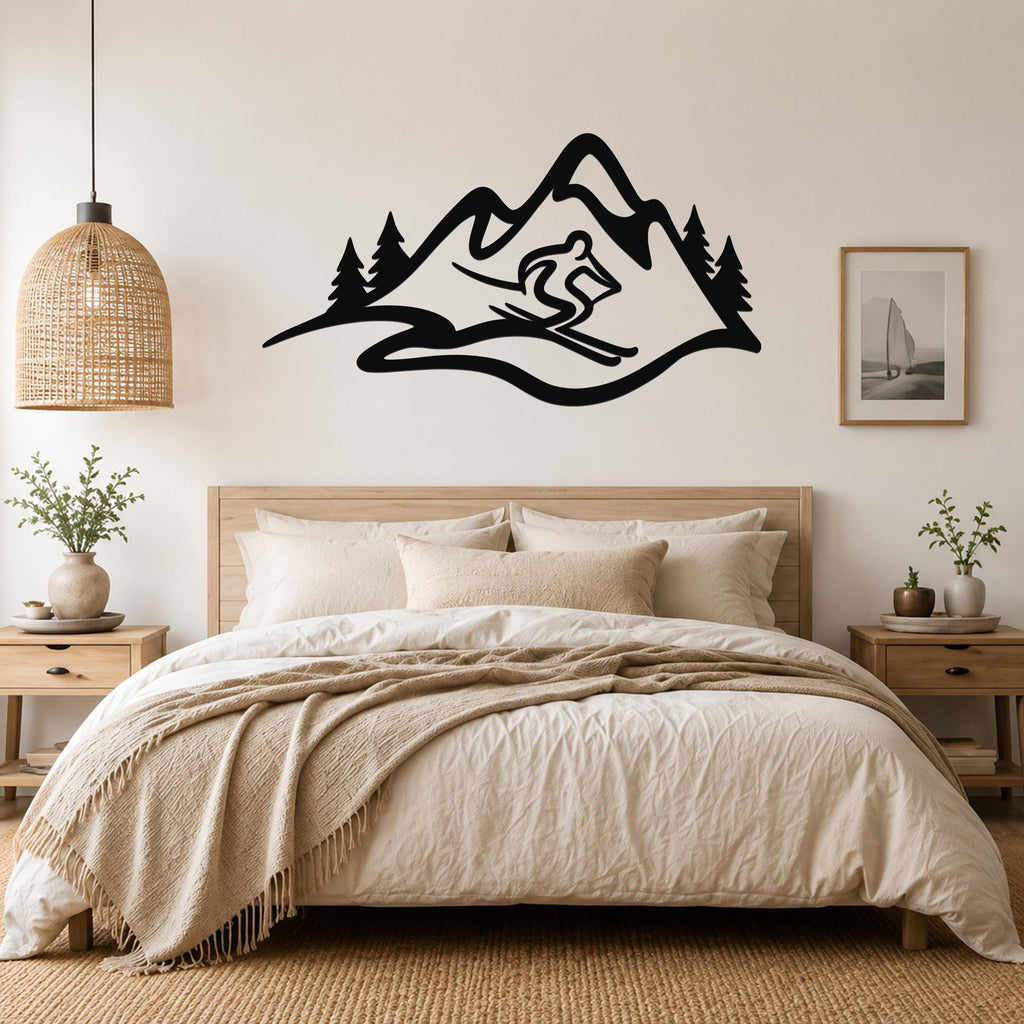 Black metal wall art featuring a skier silhouette and mountain range with pine trees, mounted above a bed in a bedroom.